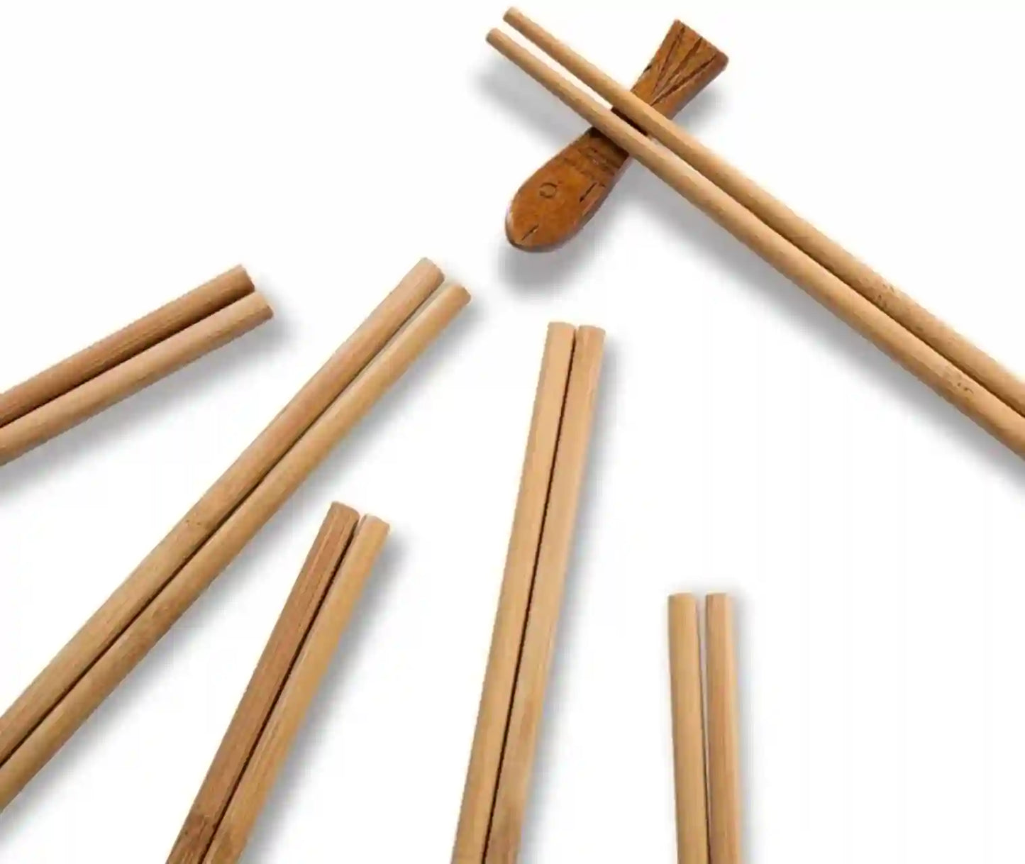 Several light natural wood chopsticks arranged on a plain white background, with one pair resting on a matching wooden chopstick holder.
