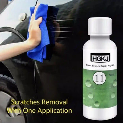 Car scratch repair agent bottle with a hand using a blue cloth on a car surface.