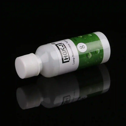 A small white plastic lamp refill bottle with a white cap, featuring a green and white label with the brand name 'HASK' and the number '8', set against a solid black background with a clear reflection below.