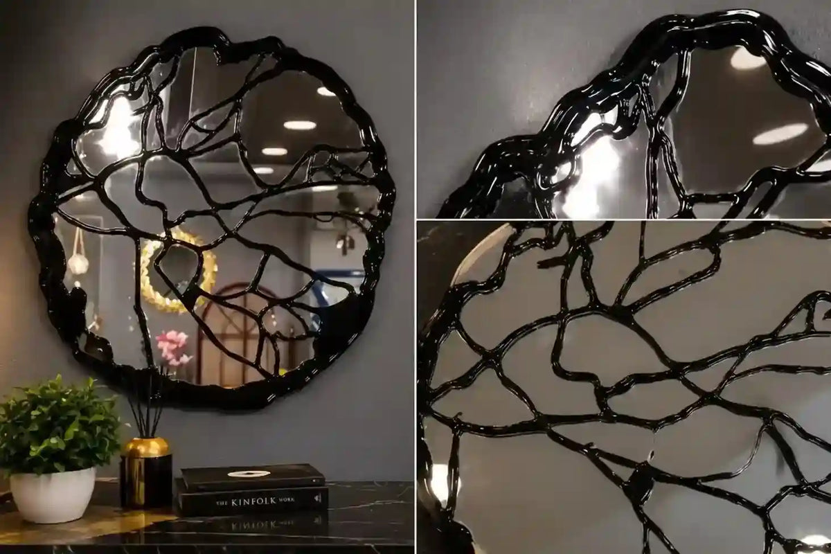 An organic-shaped black mirror with a glossy, crackled branch-like frame, shown in a split view: a full product shot on a gray wall above a table with a plant and books, and two close-up detail panels highlighting the textured black frame.
