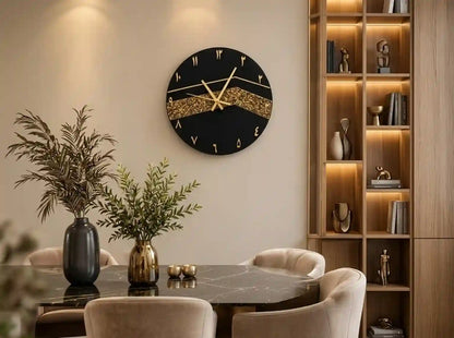 A round black wall clock with gold Roman numerals and a glittery gold wave design across the center, mounted on a beige wall in a modern dining room setting.