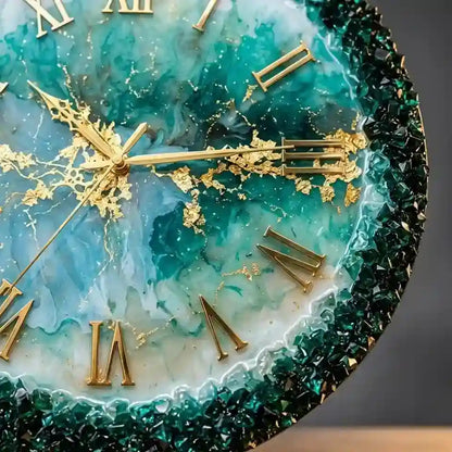 Close-up of a decorative wall clock face with a teal and aqua marbled design, gold Roman numerals, gold hands, and a dark green faceted crystal-like border.