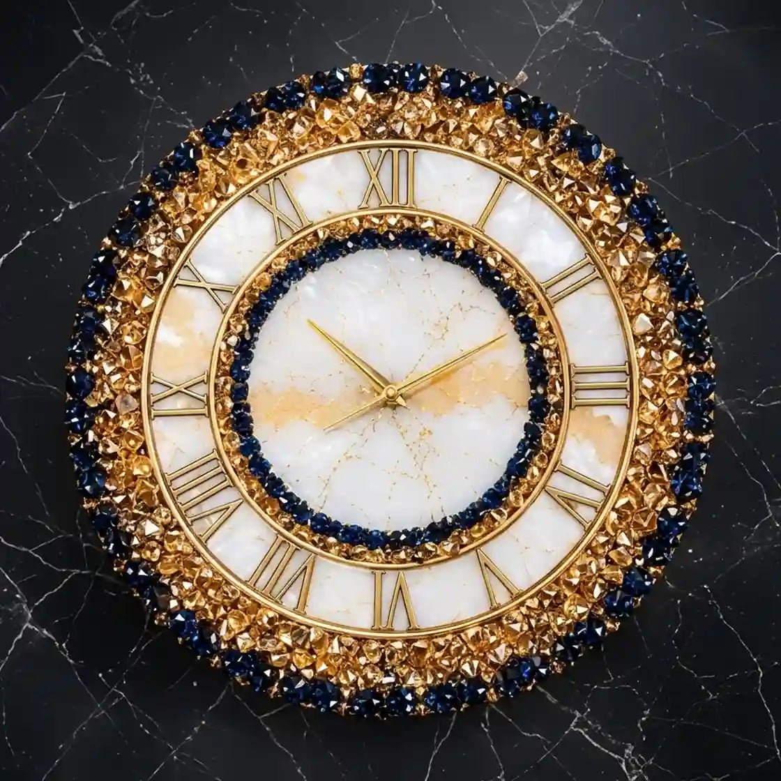 An ornate round wall clock with a gold-tone frame, white marble dial, Roman numerals, and dark blue gemstone accents, shown against a dark marble background.