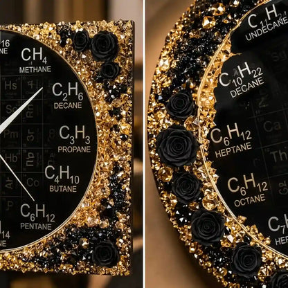 A decorative square wall clock shown in a close-up split view. The clock face is black with white periodic-table-style text labeling different alkanes, surrounded by a border of black and gold glitter and black fabric roses.