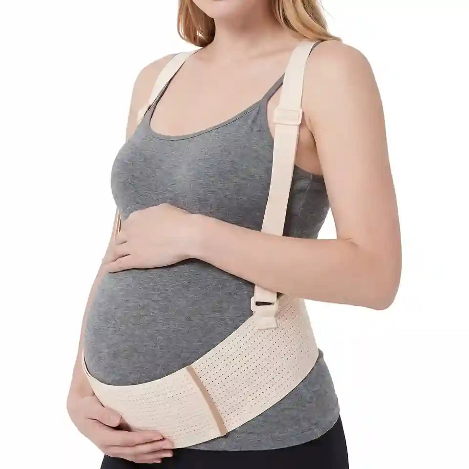 Pregnant woman wearing a beige maternity support belt on a white background