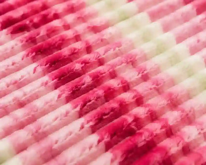 A close-up view of a pleated fabric or felt material with alternating rows of pink, magenta, and off-white textured tubes or slats.