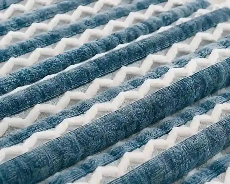 Close-up of a textured fabric surface with repeating diagonal stripes in blue and white.