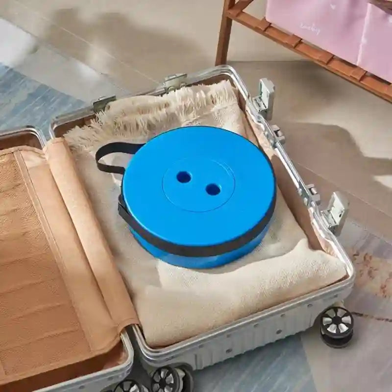 Blue spool with black handle inside an open suitcase on a tiled floor.