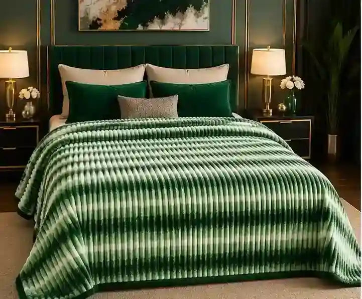 A green and white striped ribbed blanket draped over a bed in a styled bedroom setting with matching green pillows, bedside tables, lamps, and wall decor.