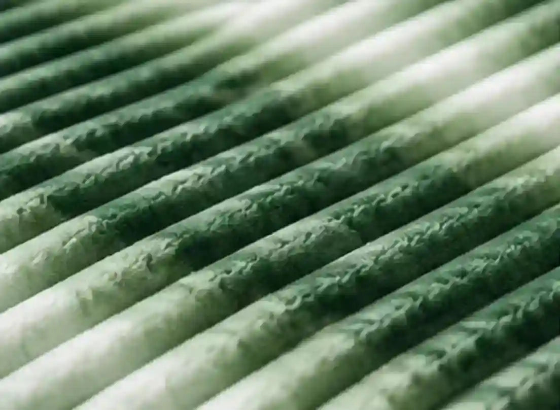 Close-up of a pleated filter element with green and white pleated fabric layers.