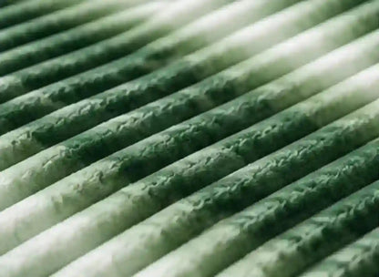Close-up of a pleated filter element with green and white pleated fabric layers.