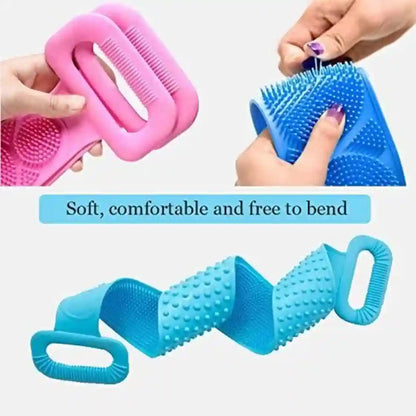 A silicone pet grooming brush with dual colors shown in use and as a standalone product. The top half shows a pink version being held by hands and a blue version being used to groom a dog, with text reading 'Soft, comfortable and free to bend.
