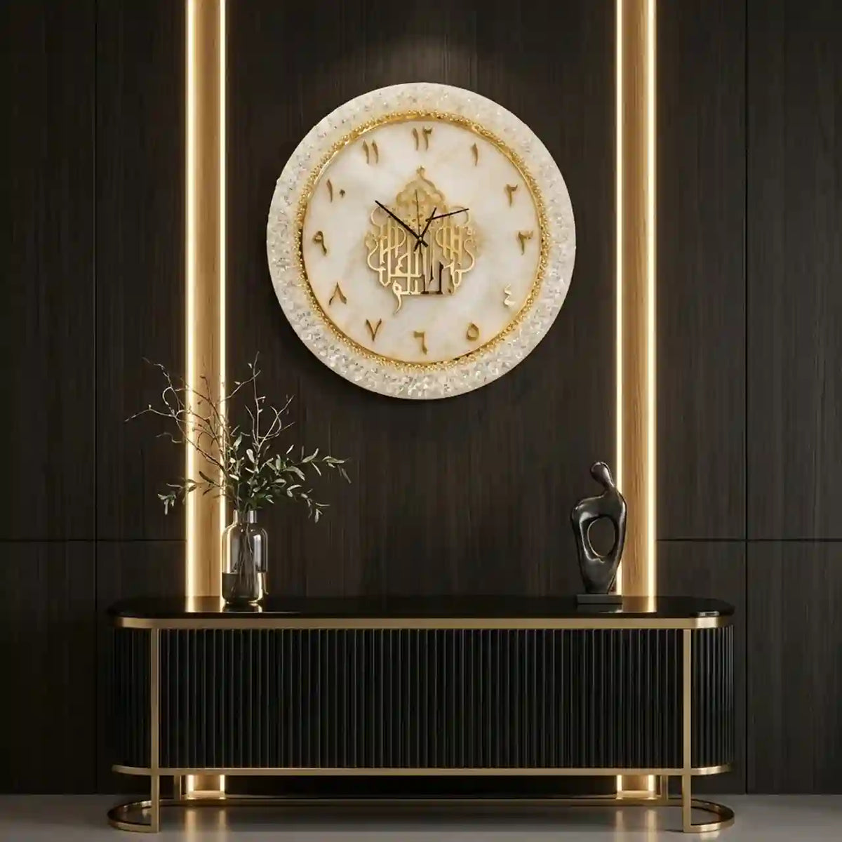 A round wall clock with a cream and gold marbled face and Arabic numerals, mounted on a dark wood-paneled wall above a black console table with gold accents.