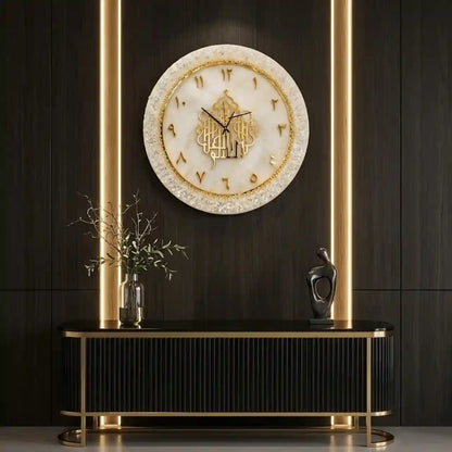 A round wall clock with a cream and gold marbled face and Arabic numerals, mounted on a dark wood-paneled wall above a black console table with gold accents.