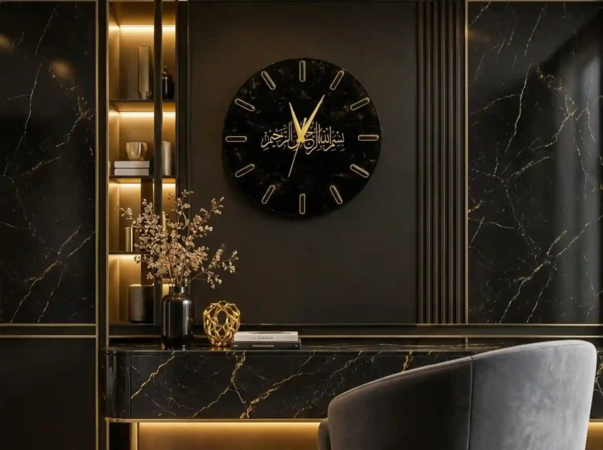A round black marble wall clock with gold Arabic calligraphy hands and markers, mounted on a dark wood-paneled wall above a console table with a gray chair in a luxury interior.