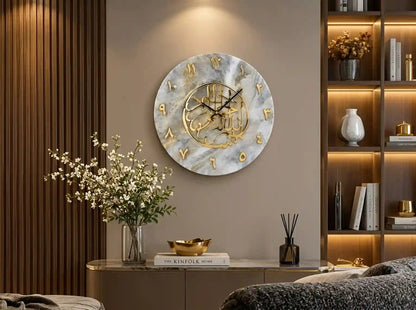 A round wall clock with a white and gray marble pattern, gold Arabic numerals, and a gold central medallion, mounted on a beige wall in a modern, warmly lit living room setting.