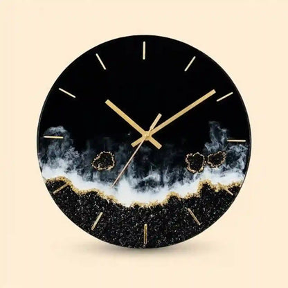 A round wall clock with a black face and frame, featuring gold hands, gold hour markers, and a textured black-and-white geode or smoky wave design near the bottom, shown on a light beige background.